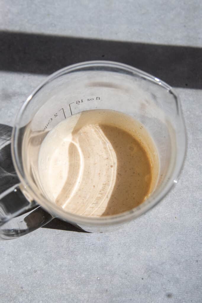 Frothed pumpkin cold foam thickened to a pourable texture that coats the back of a spoon.