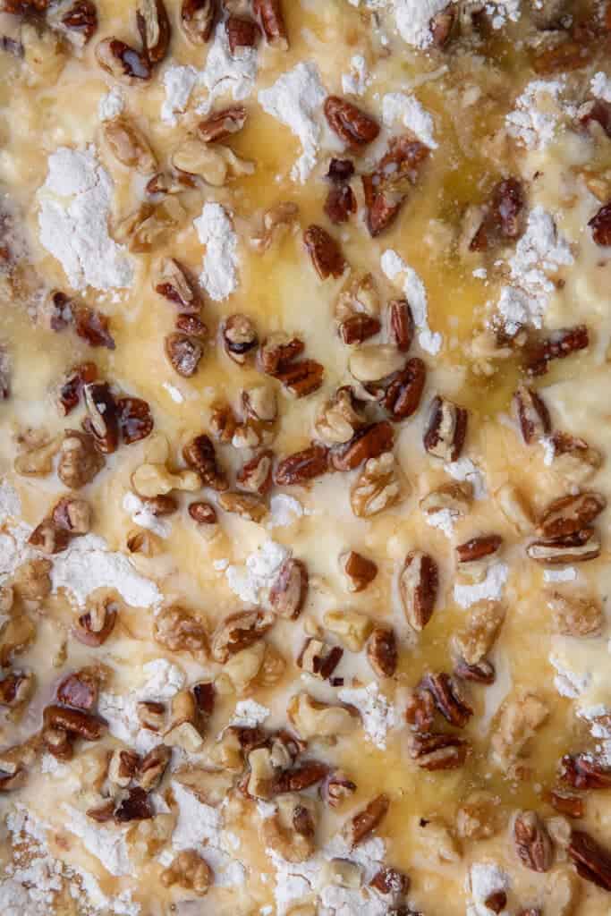 Melted butter drizzled over the cake mix and pecans, soaking the dry patches before baking.