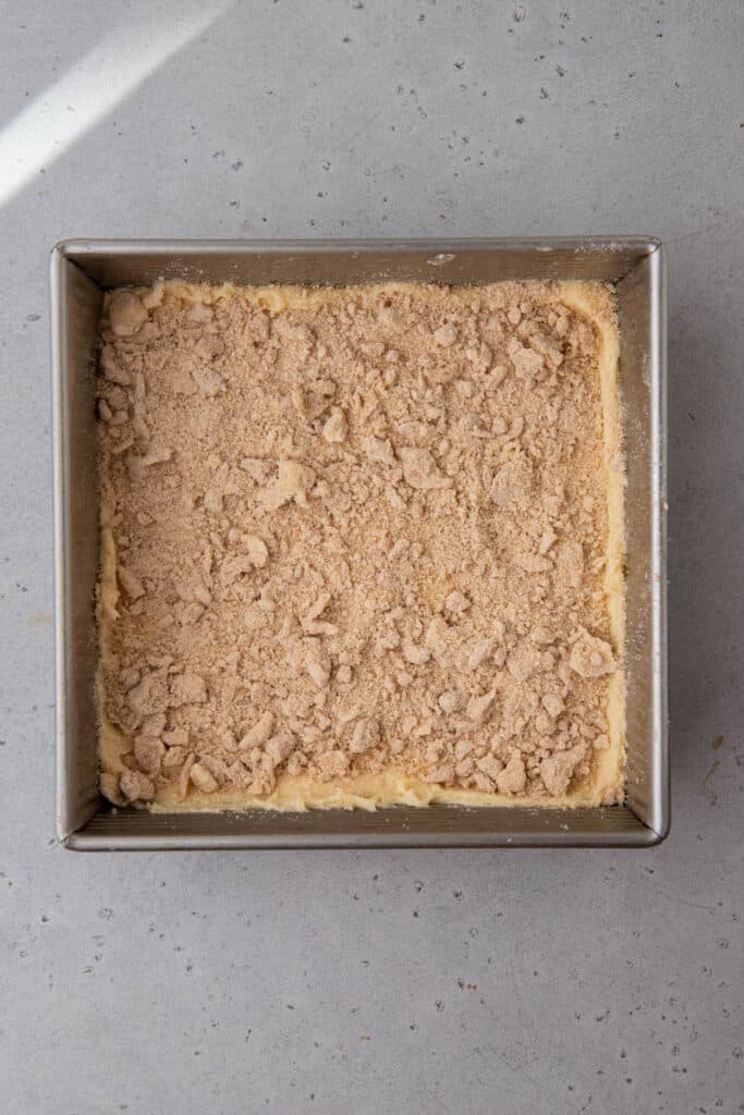 Cinnamon crumble layer sprinkled over the cake batter in the pan, the signature Starbucks coffee cake middle stripe.