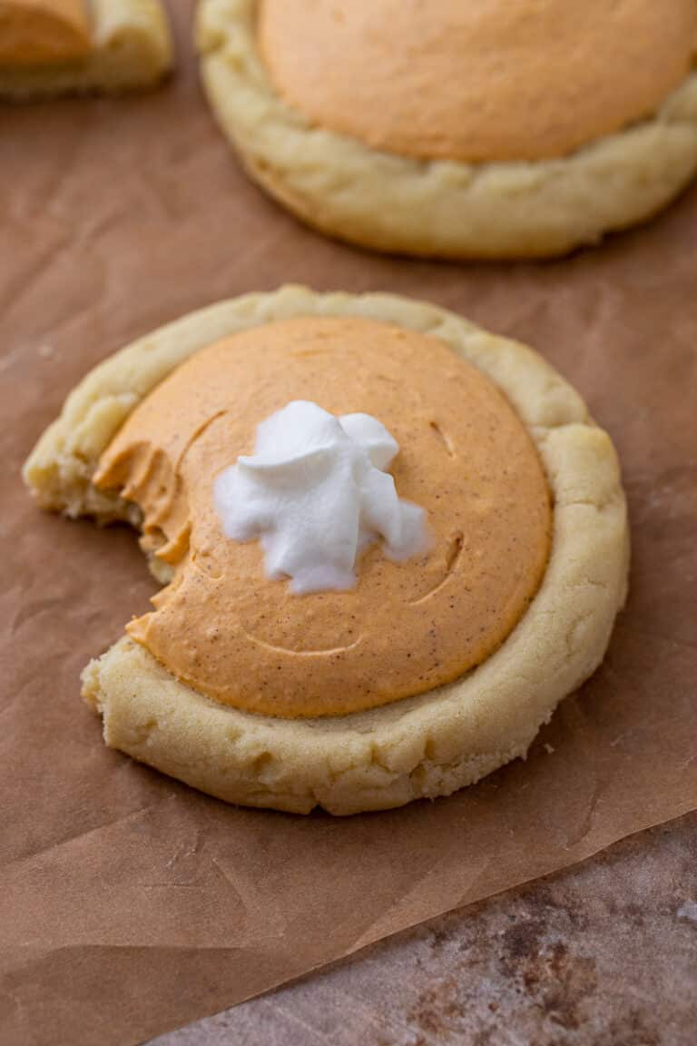 Crumbl pumpkin pie cookie with a bite taken out of it