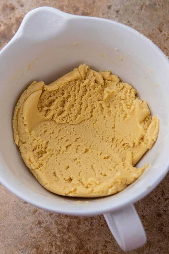 Sugar cookie dough for Crumbl pumpkin pie cookies mixed together in a large bowl.