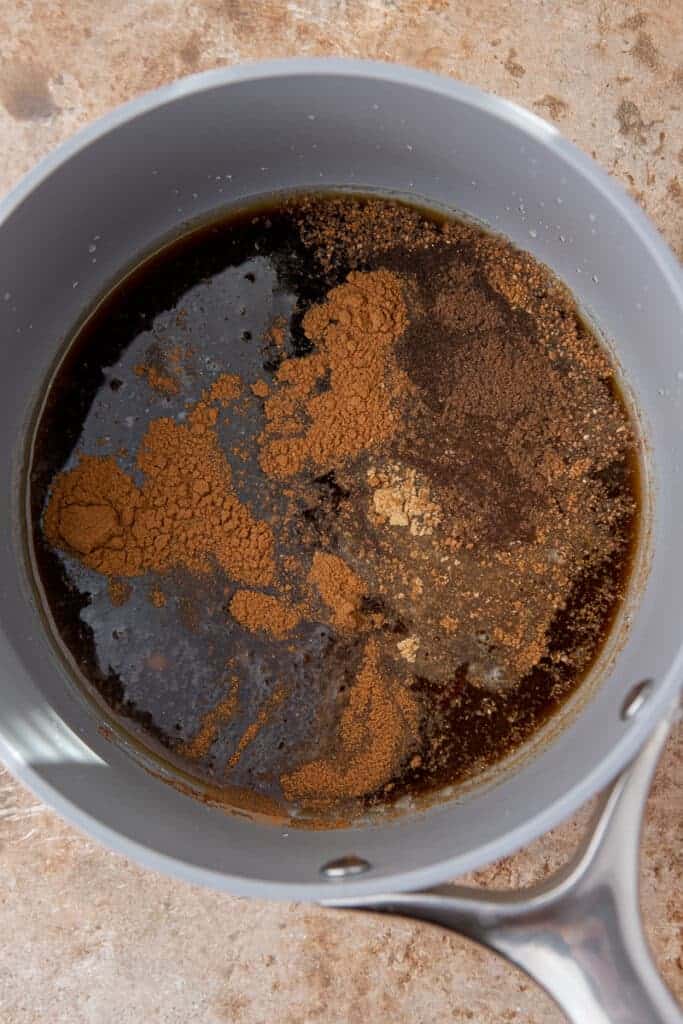 Spices, sugar, and water mixed in a small saucepan before simmering