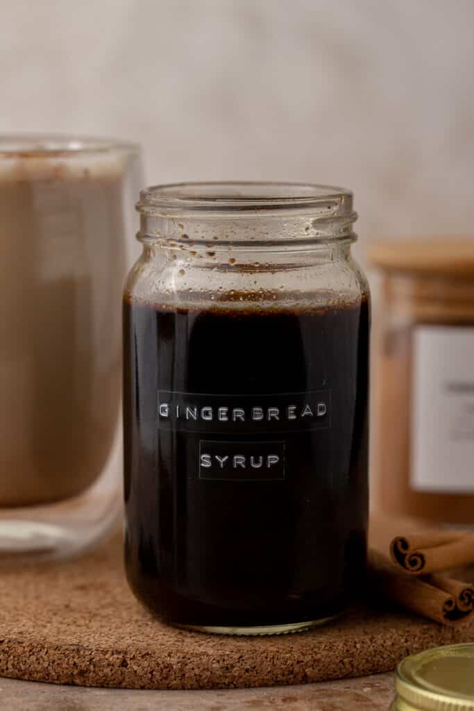 Homemade gingerbread coffee syrup in a labeled glass mason jar