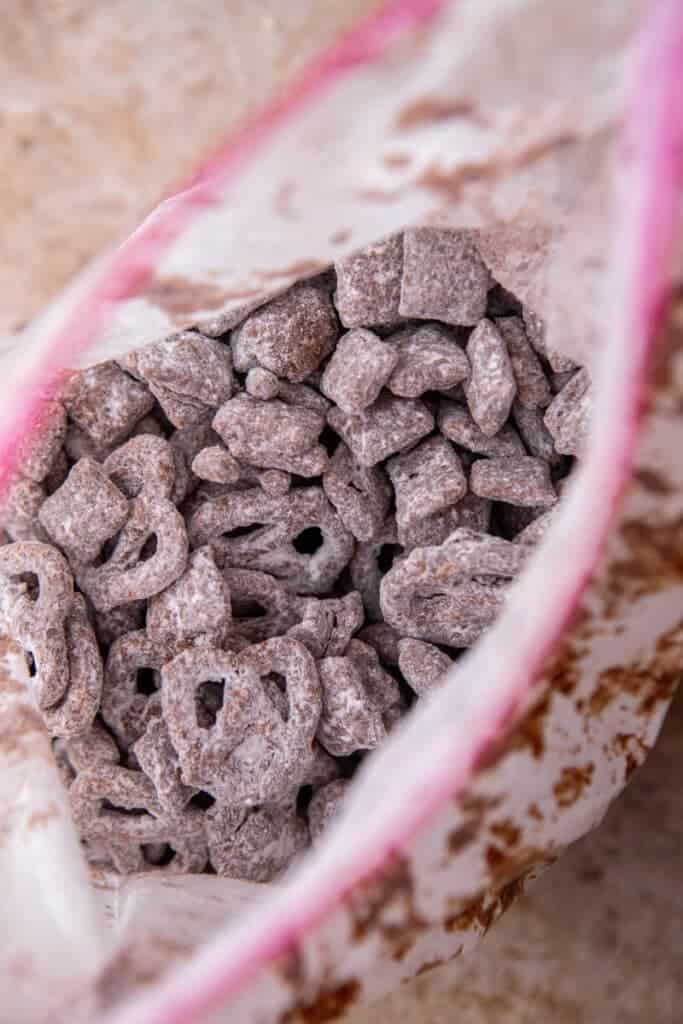 Muddy buddies tossed with powdered sugar in resealable bag