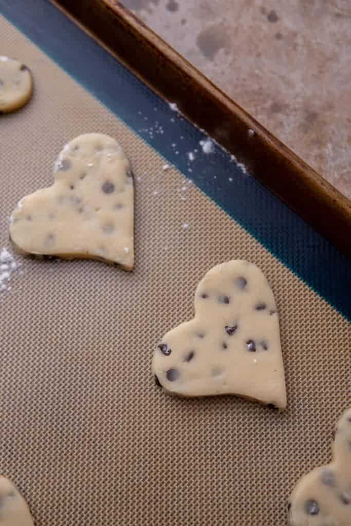 Heart-shaped chocolate chip cookies on a baking sheet