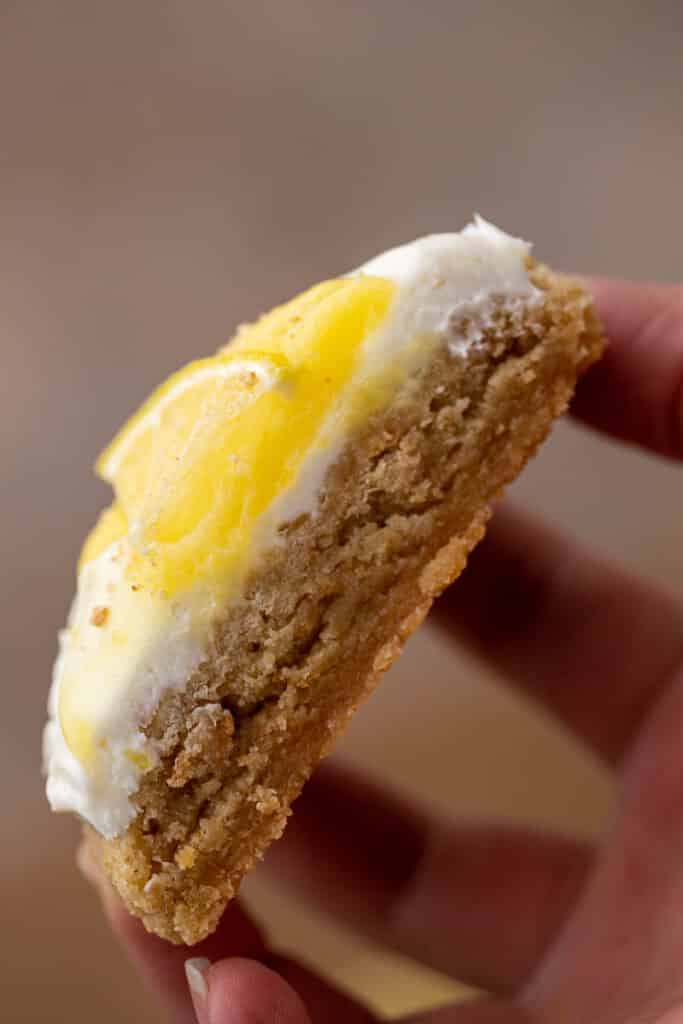 Sliced lemon cheesecake cookie in hand