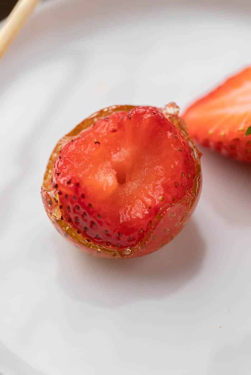 Candied strawberry tanghulu with a bite taken out of it