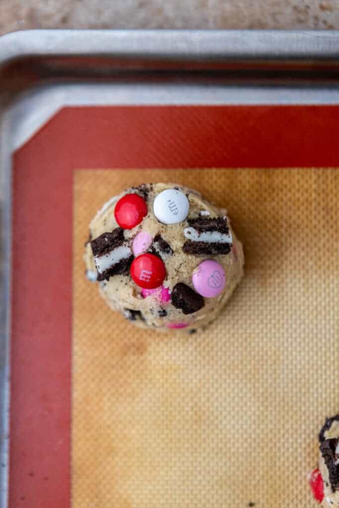 Scooped Valentine’s Day Oreo M&M cookie dough on baking sheet