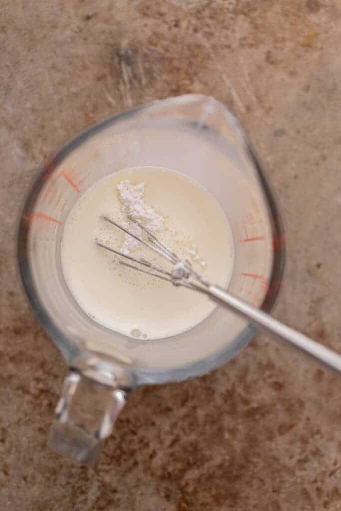 Whisking sweet cream mixture in measuring cup