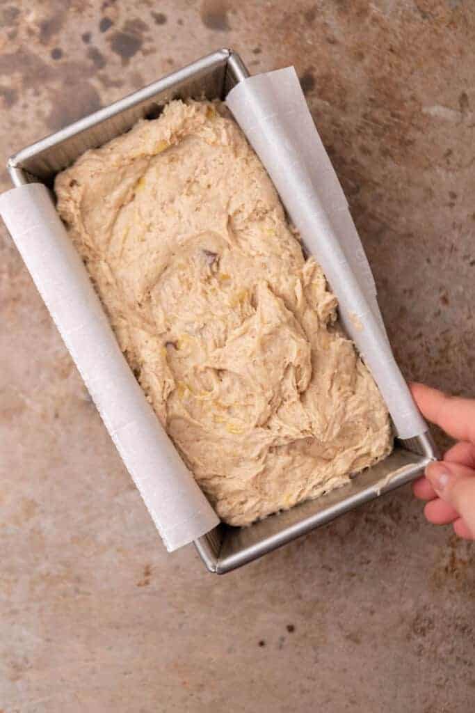 Quick bread batter in a parchment-lined loaf pan ready to bake