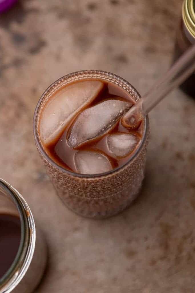 Shaken chocolate cold brew poured over a glass of ice before the milk goes in.