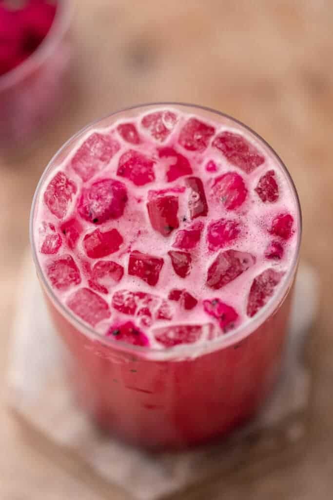 Creamy pink drink with ice and fruit pieces