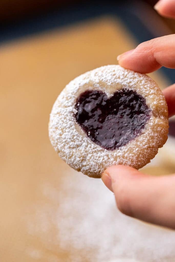Hand holding thumbprint cookies