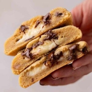 Hand holding cheesecake stuffed chocolate chip cookies