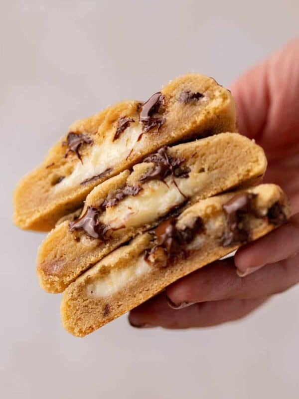 Hand holding cheesecake stuffed chocolate chip cookies