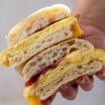 Hand holding Starbucks bacon egg and cheese sandwich