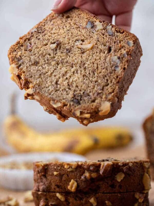 Hand holding slice of banana bread