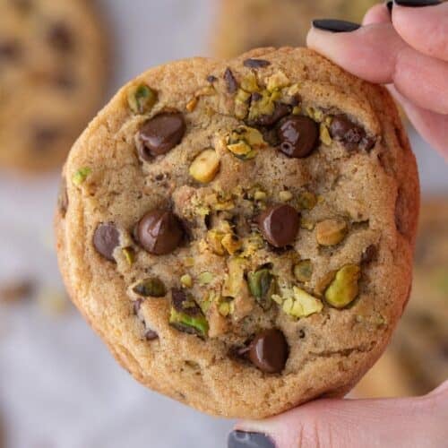 Hand holding Brown butter pistachio chocolate chip cookies