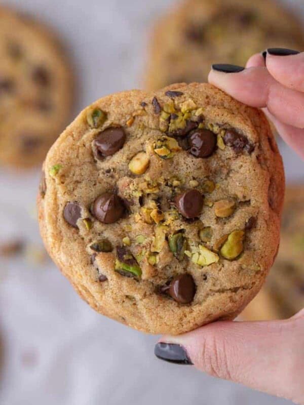 Hand holding Brown butter pistachio chocolate chip cookies