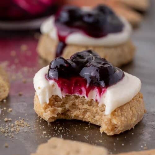 ini Crumbl blueberry cheesecake cookies with a bite taken out of them