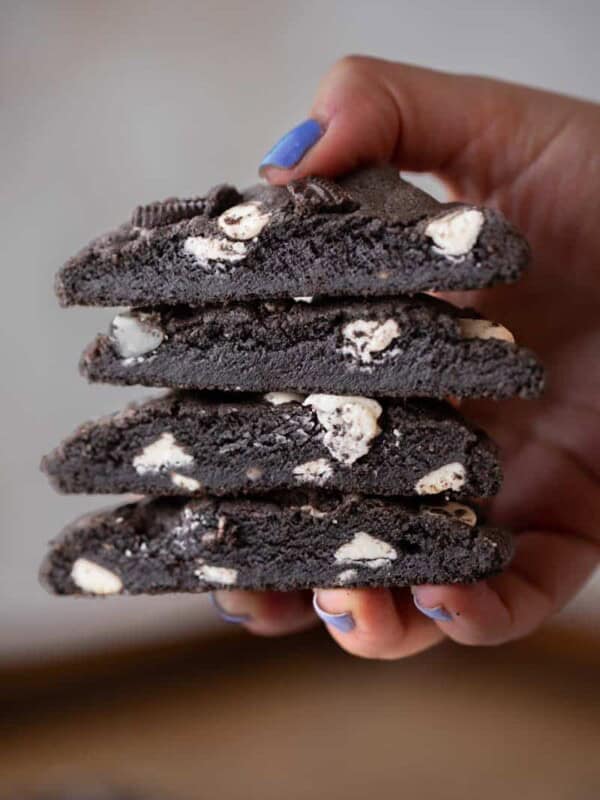 Hand holding stack of chocolate cookies and cream cookies