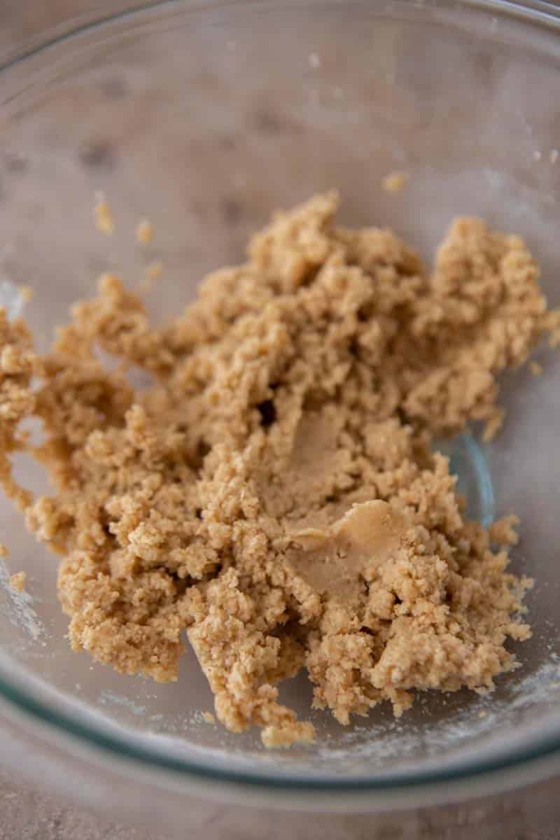 Crumbly graham cracker cookie dough in a glass bowl.