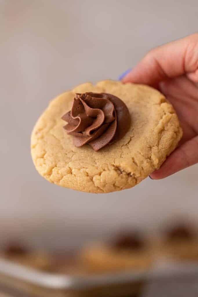 Hand holding Crumbl peanut butter blossom cookies