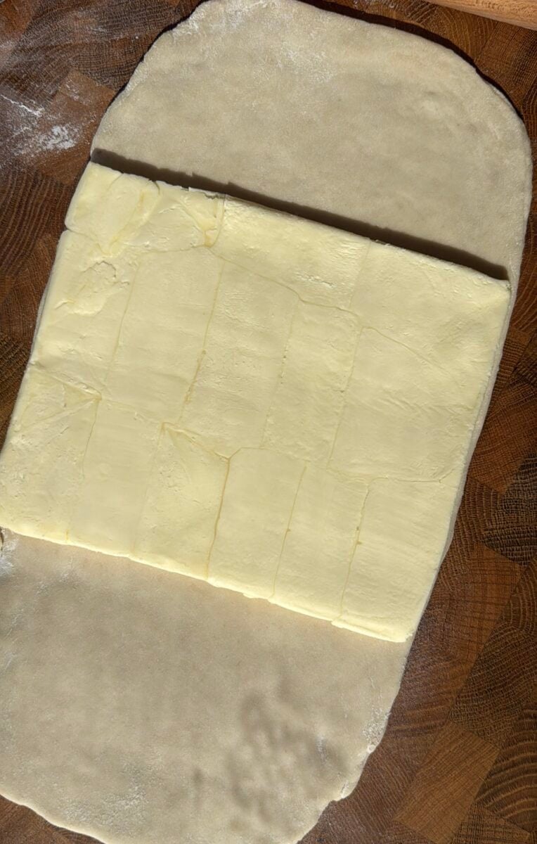 Butter block placed inside rolled croissant dough before folding
