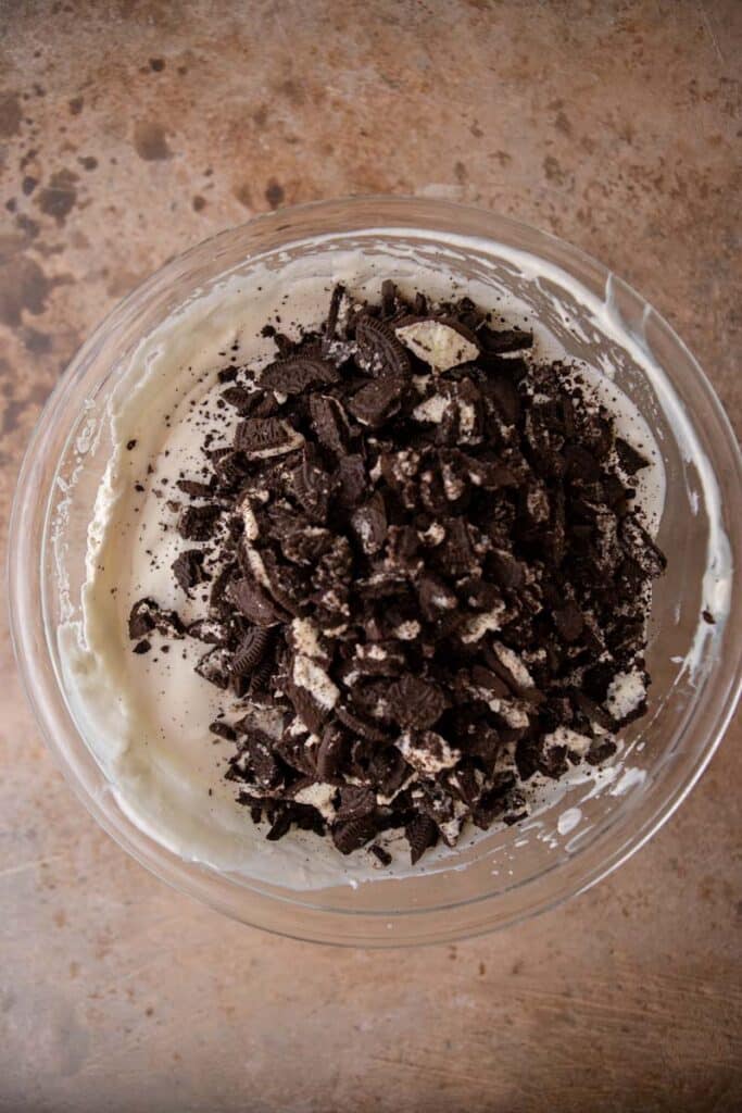 Whipped cream and sweetened condensed and Oreos milk on a bowl