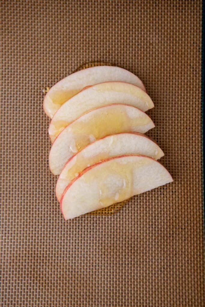 Apple slices and honey on baking sheet