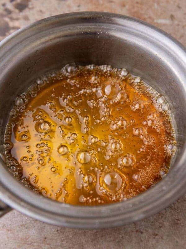 Homemade caramel coffee syrup bubbling in a small saucepan on the stovetop