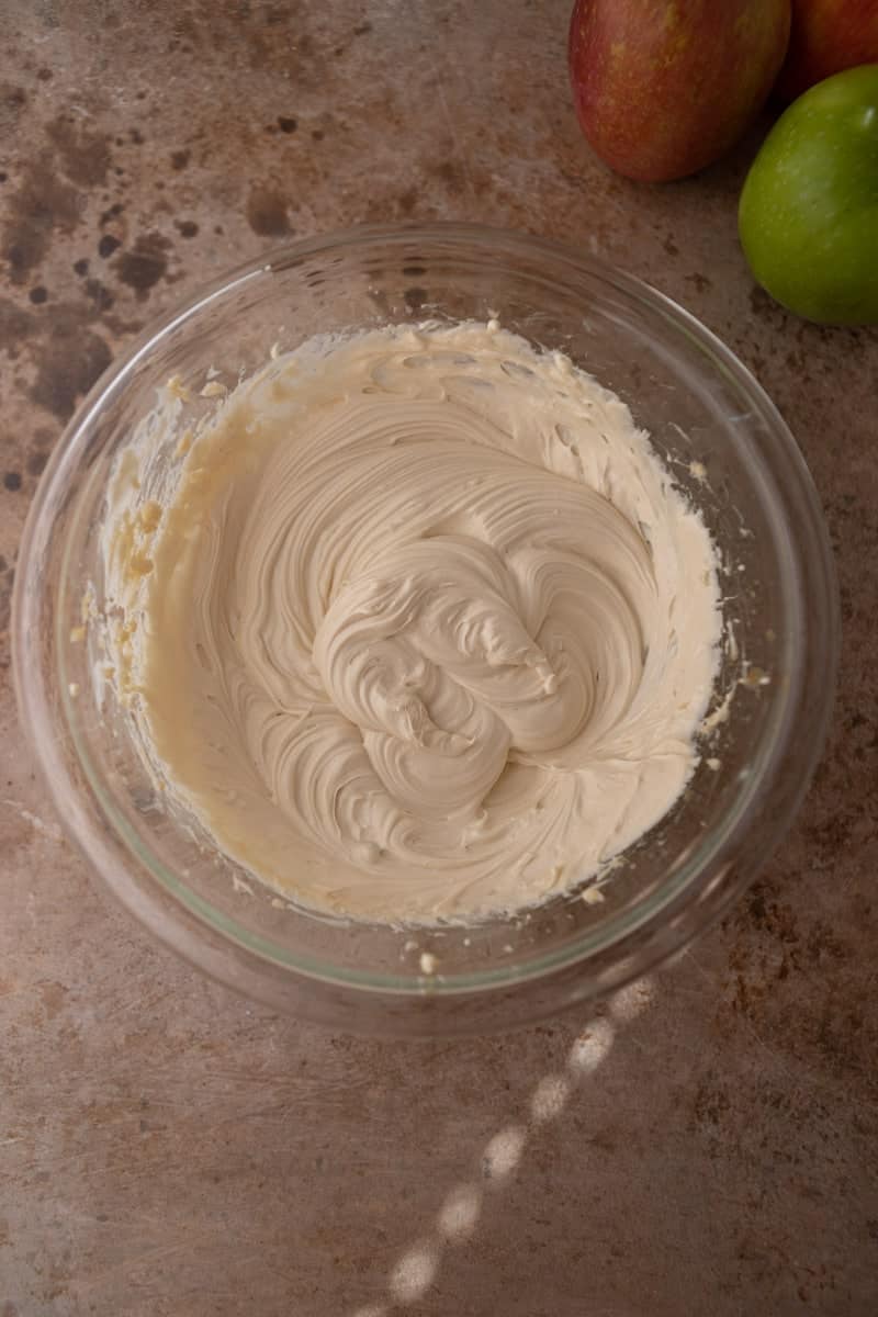 Fluffy no-bake cheesecake mixture in a glass bowl.