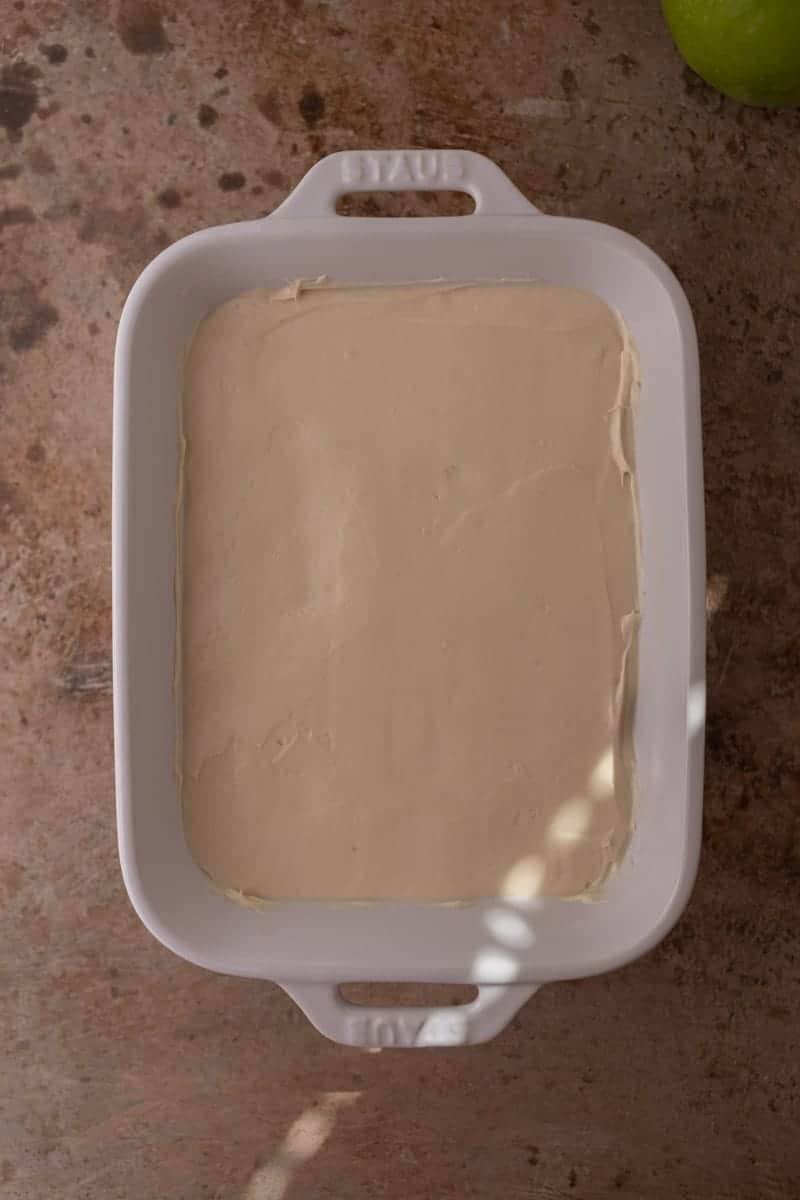 Cheesecake layer spread into a white rectangular serving dish.
