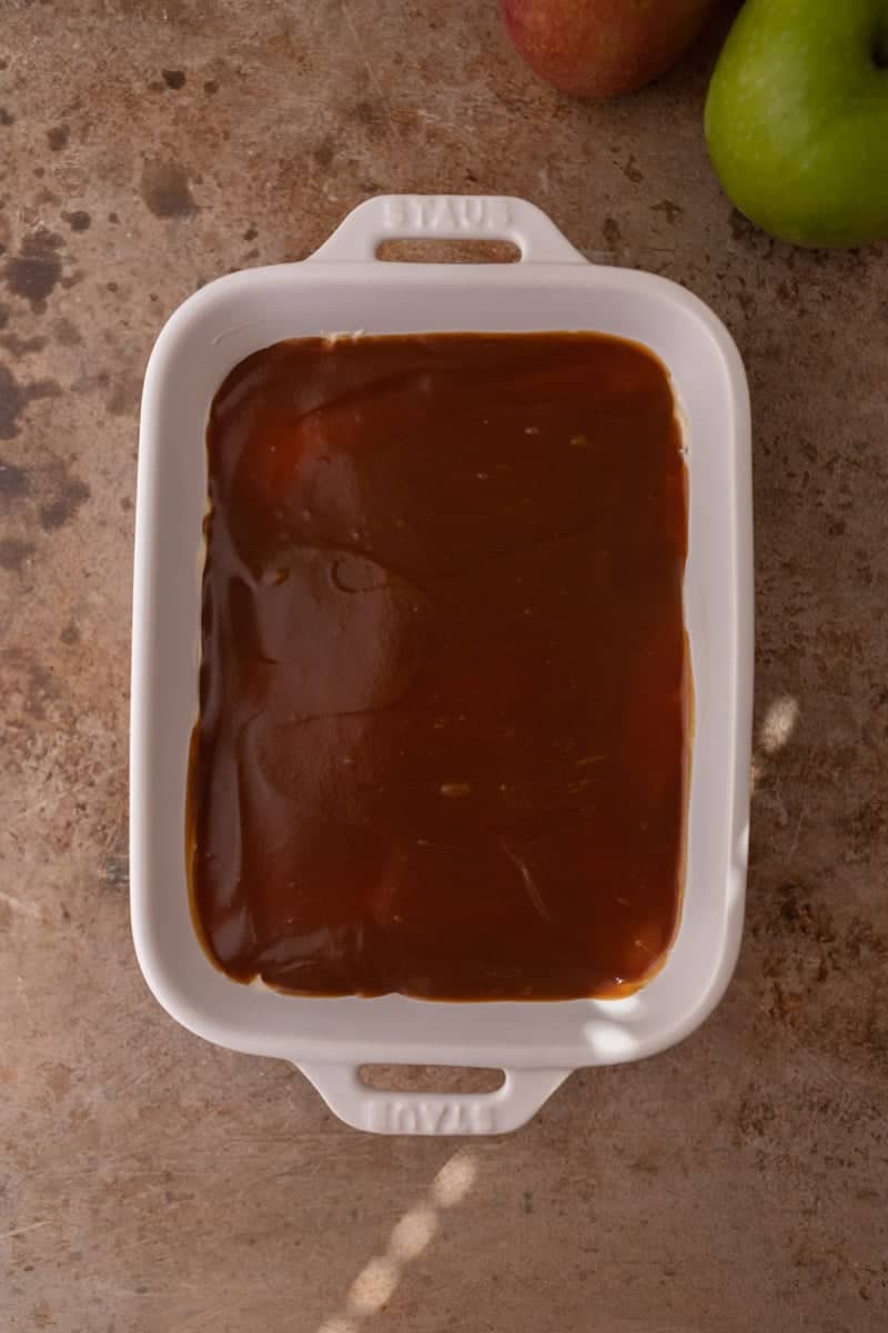 Caramel sauce spread over the cheesecake layer in a serving dish.