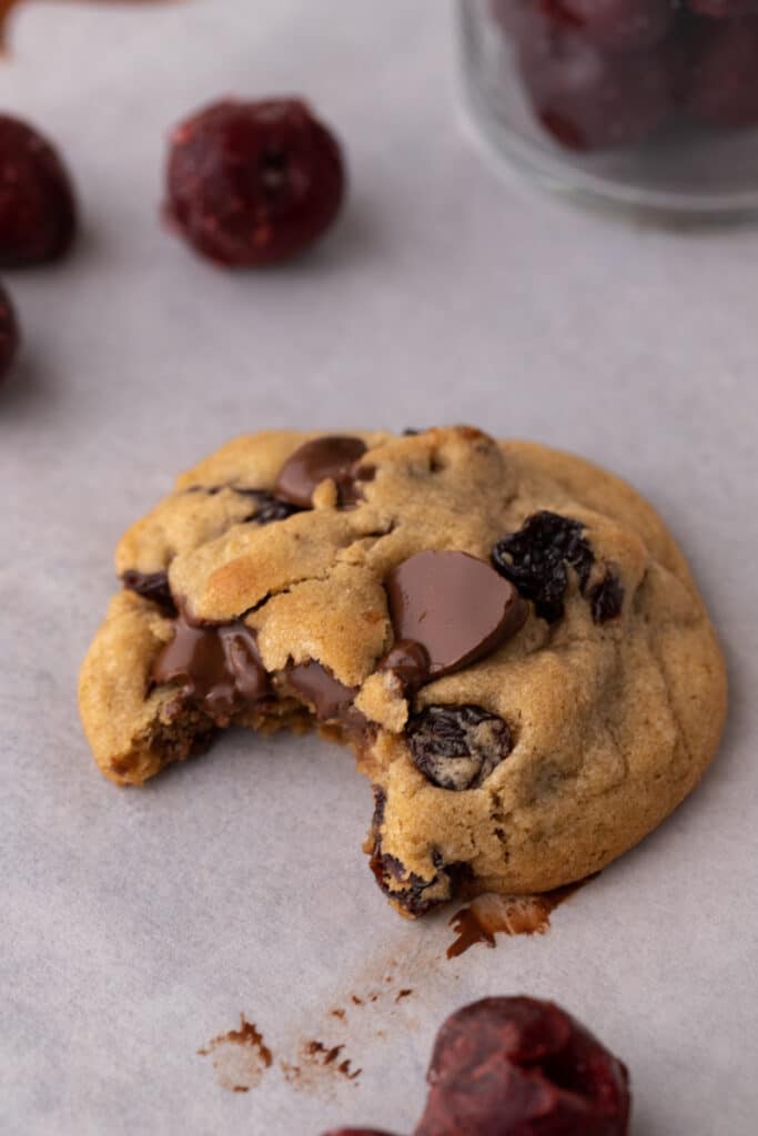 a brown butter cherry chocolate chip cookie with a bite taken out