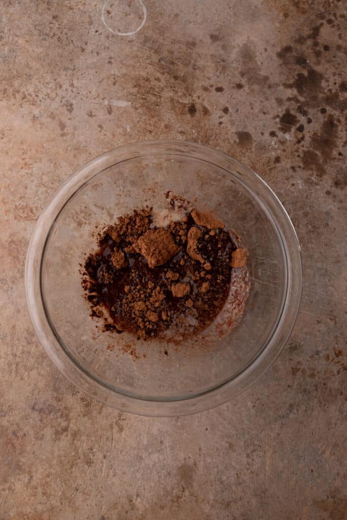 the butter and cocoa powder of the brownie frosting recipe melted together in a bowl
