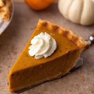 slice of pie on a spatula that's on a table from the recipe for two pumpkin pies