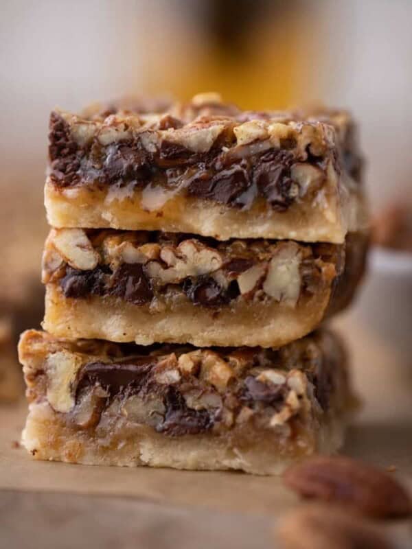 3 chocolate pecan pie bars stacked on top of each other