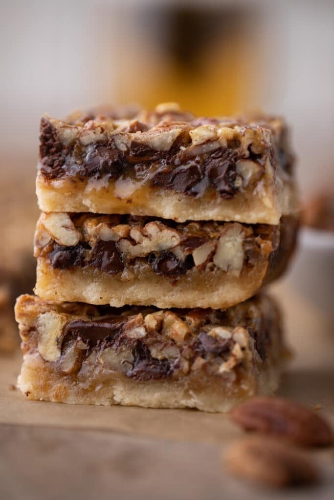 3 chocolate pecan pie bars stacked on top of each other