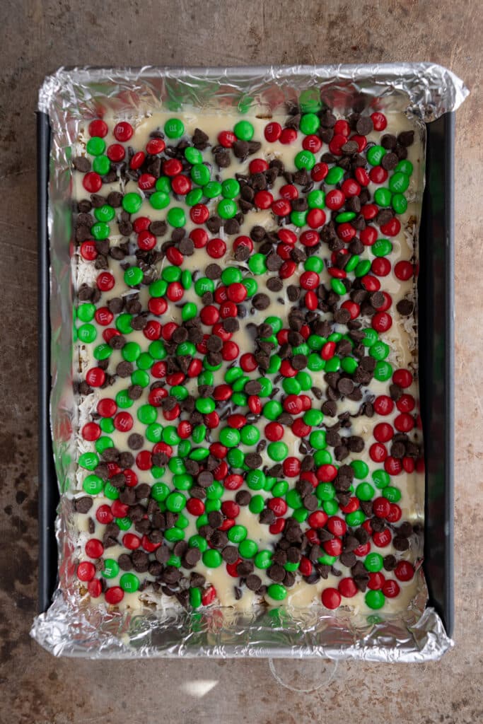 unbaked christmas magic cookie bars in a pan