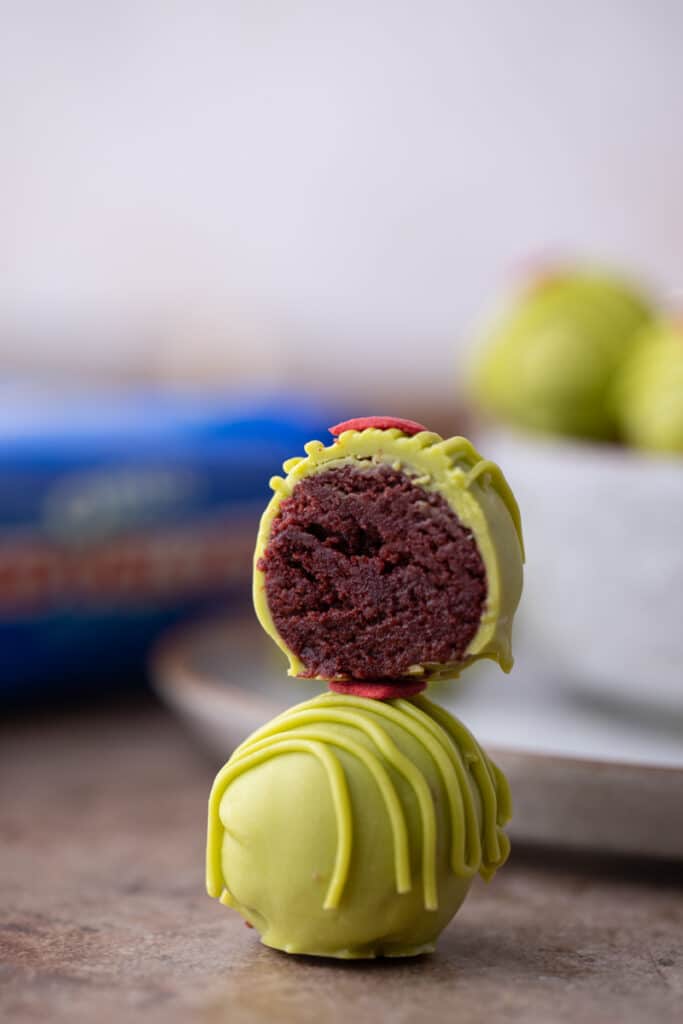 a grinch oreo truffle split in half, on top of a whole one