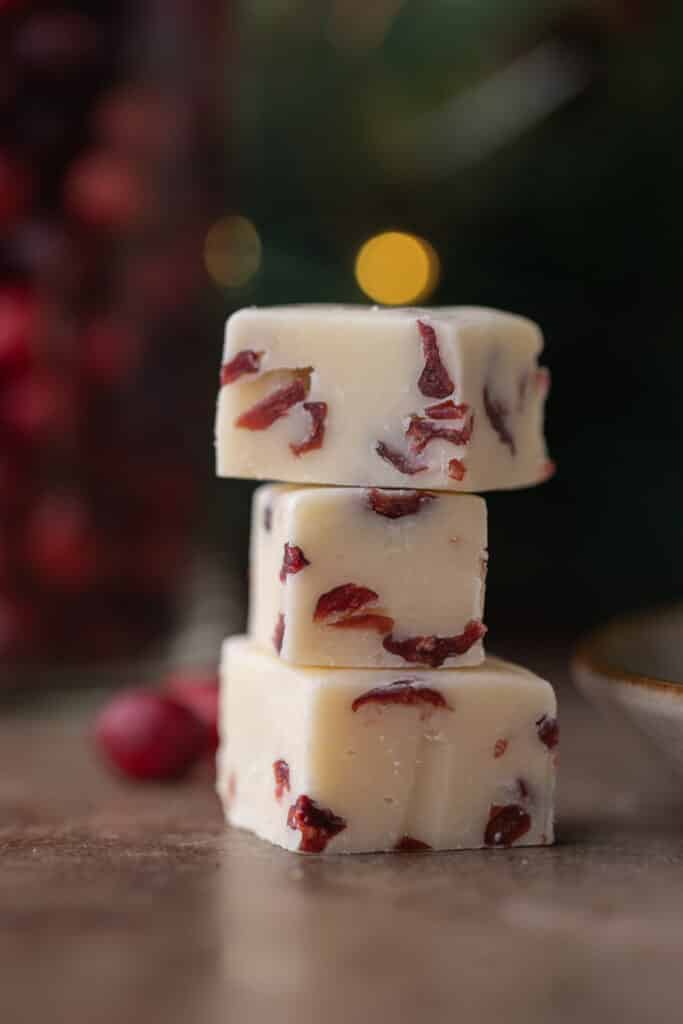 three squares of cranberry white chocolate fudge stacked on top of each other