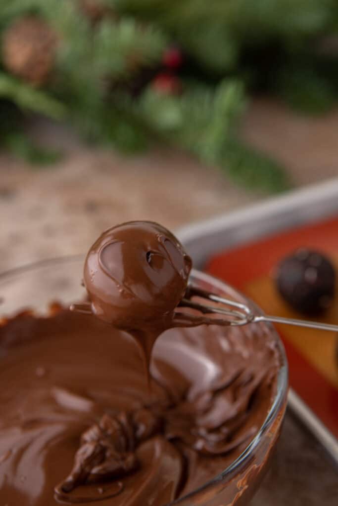 a ball being held up by a chocolate dipping fork