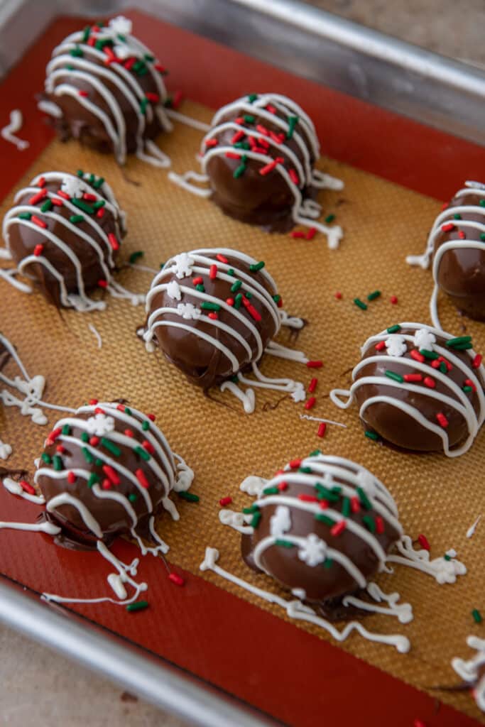 multiple finished Little Debbie Chocolate Christmas tree cakes truffles lined up on a baking sheet