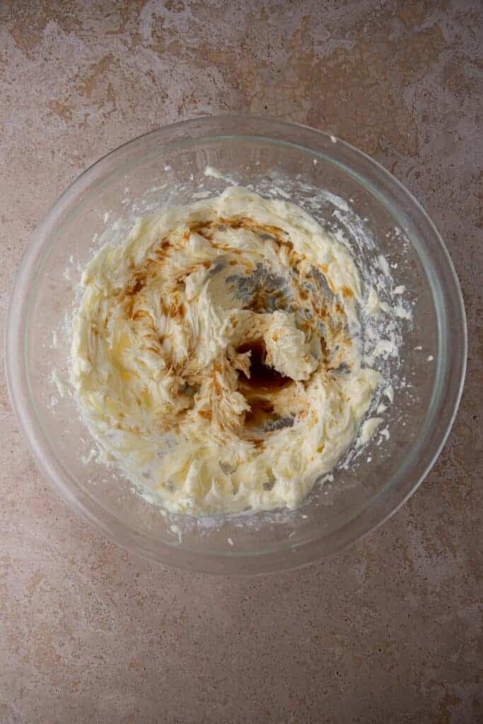 Creamed butter and sugar mixture with vanilla in a glass bowl.