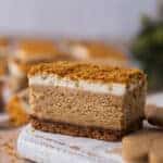 Close-up of a gingerbread cheesecake bar with creamy spiced filling, gingersnap crust, and crumb topping.”