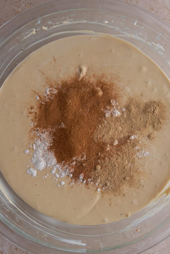 spices on top of the batter in a bowl