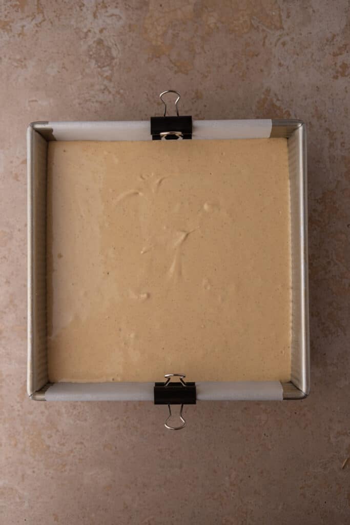 raw batter of the gingerbread cheesecake bars in a pan