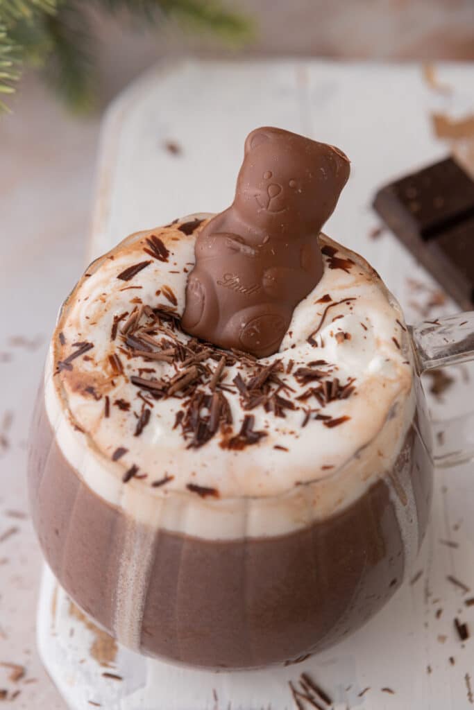 a chocolate bear floating on whipped cream in a glass