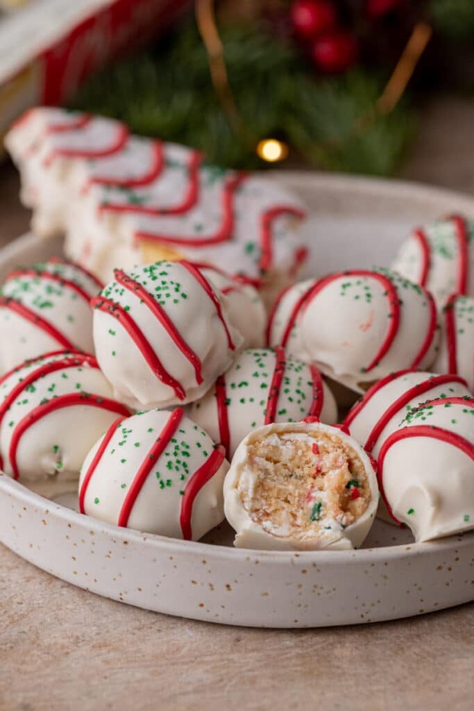 multiple little debbie christmas tree cakes truffles in a bowl with one has a bite taken out